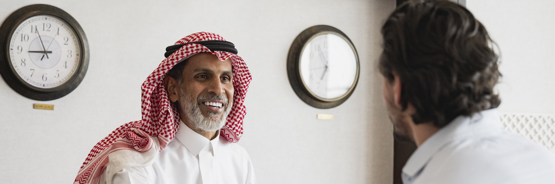 Two men talking, one smiling